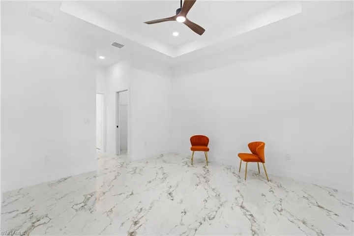 Master Bedroom featuring recessed lighting, a raised ceiling, a ceiling fan, and marble finish flooring. Separate walking closets for couples