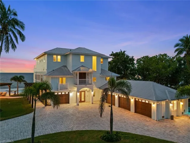 Coastal home featuring a metal roof, decorative pavers half circle driveway, water views, custom faux painted French doors. 4 car Garage and pergola covered path to pool.