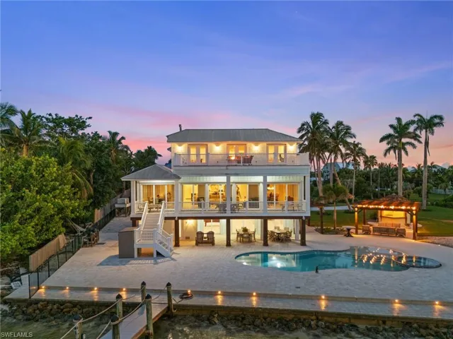 Rear view of property featuring a balcony, a pergola, stairs, a metal roof, and an outdoor pool