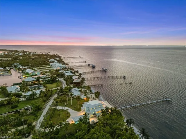 Aerial view at dusk of property and water.