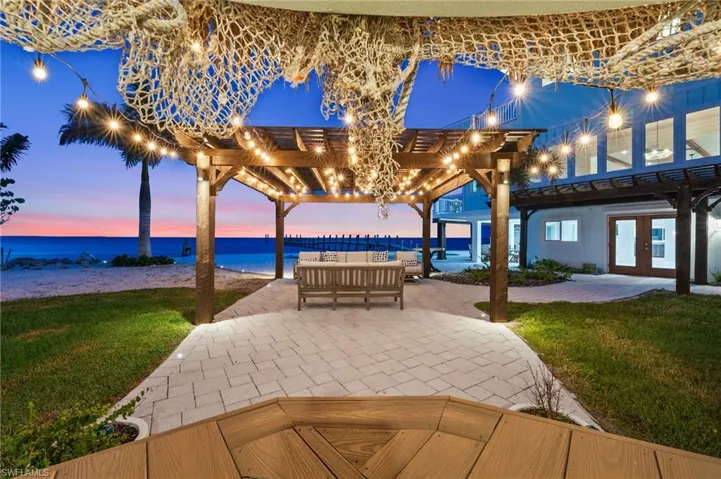 View of patio from the tiki bar / terrace with a pergola, an outdoor hangout area, a water view, and French doors into the bottom floor bonus room
