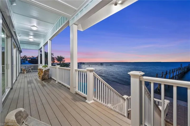Second floor deck at dusk featuring a water view