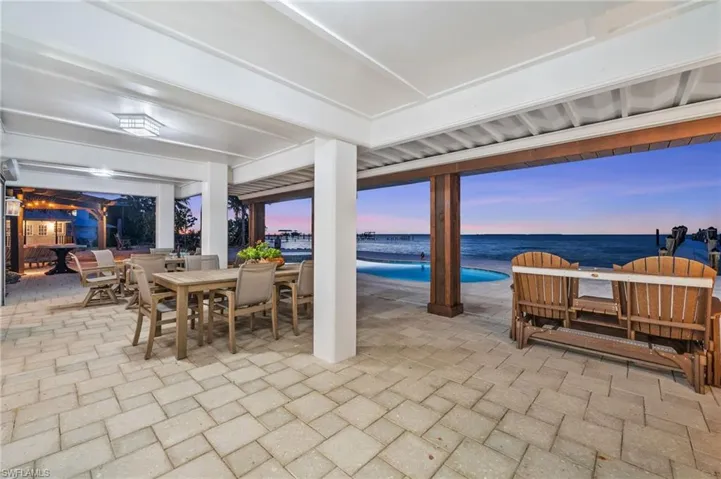 View of patio and pool looking over Charlotte Harbor and outdoor dining space