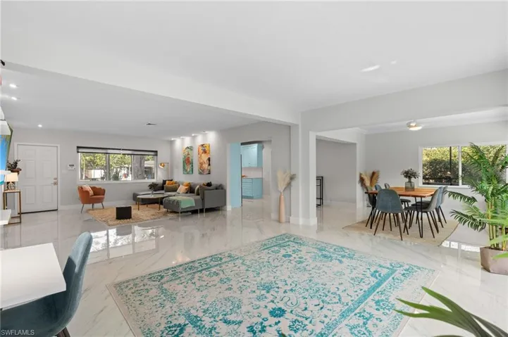 Living area featuring baseboards, recessed lighting, and marble finish floor