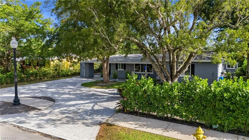 Ranch-style house featuring driveway and stucco siding