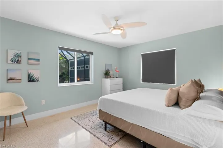 Bedroom featuring baseboards, speckled floor, and a ceiling fan