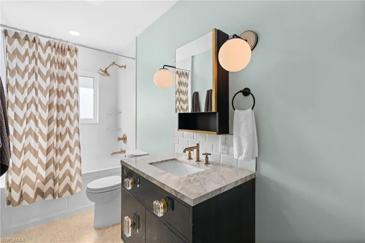 Full bathroom with shower / tub combo, toilet, and vanity