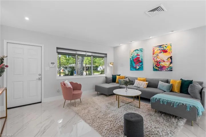 Living area featuring visible vents, baseboards, recessed lighting, and marble finish floor