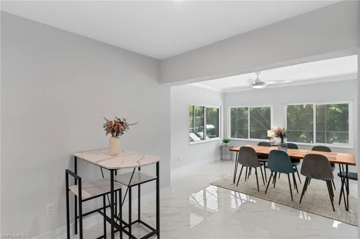 Dining space with crown molding, marble finish floor, and baseboards