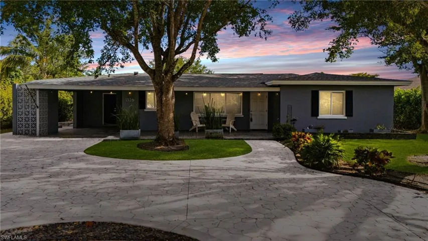 Ranch-style home featuring a carport, a yard, and driveway