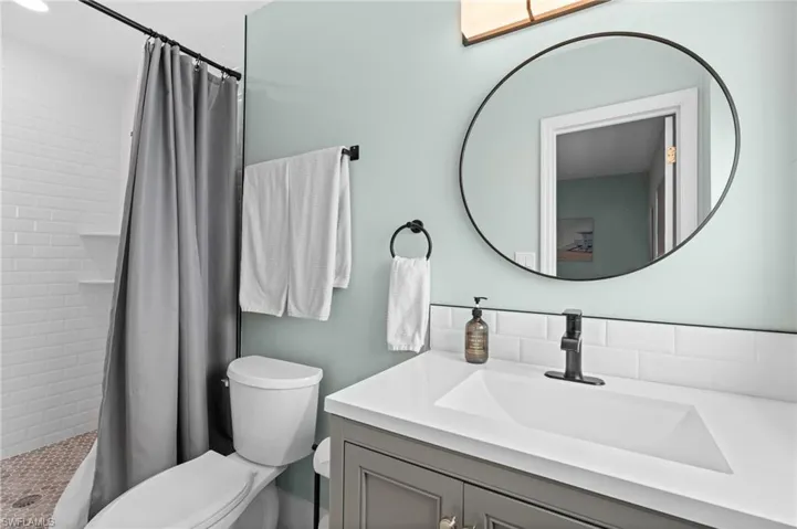 Full bath with vanity, a stall shower, and toilet