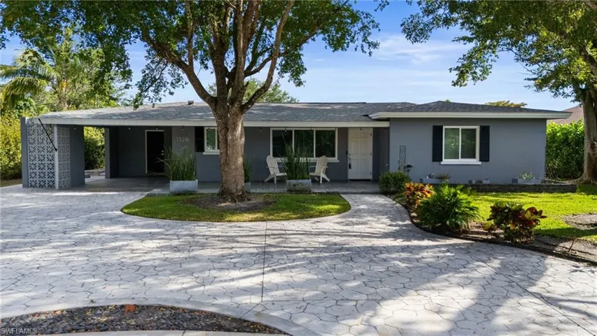 Ranch-style house with a carport, a porch, decorative driveway, and stucco siding