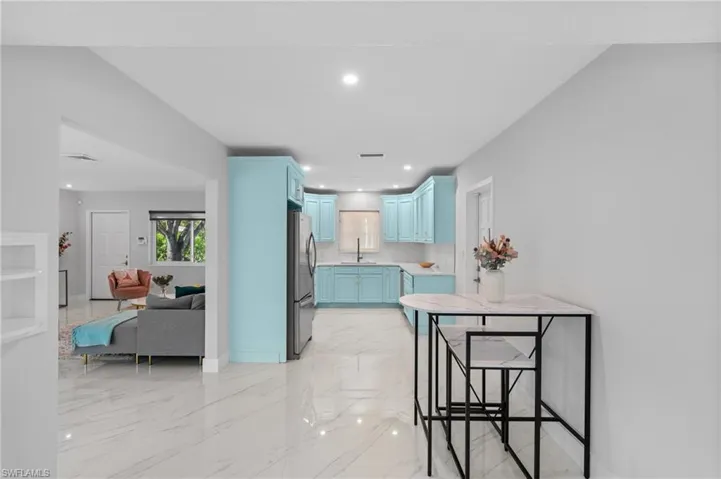 Hallway with visible vents, baseboards, a sink, recessed lighting, and marble finish floor