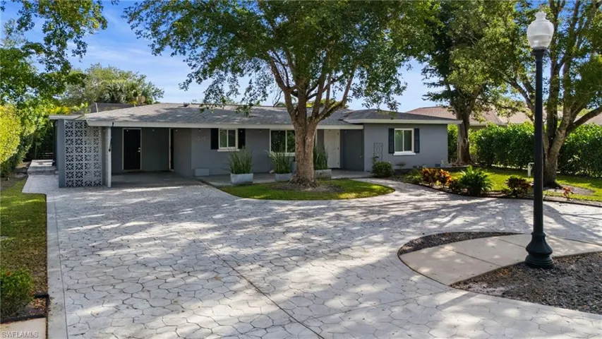 Ranch-style house with stucco siding and decorative driveway