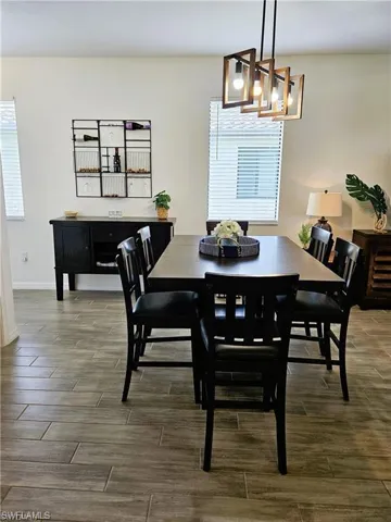 Dining space featuring baseboards, wood tiled floor, and an inviting chandelier