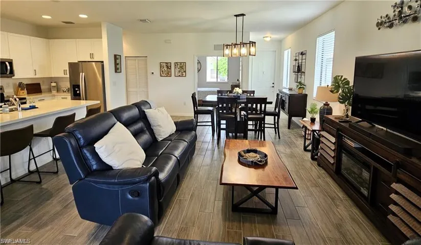 Living area with wood tiled floor, baseboards, and recessed lighting