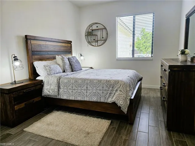 Bedroom with baseboards and wood finish floors