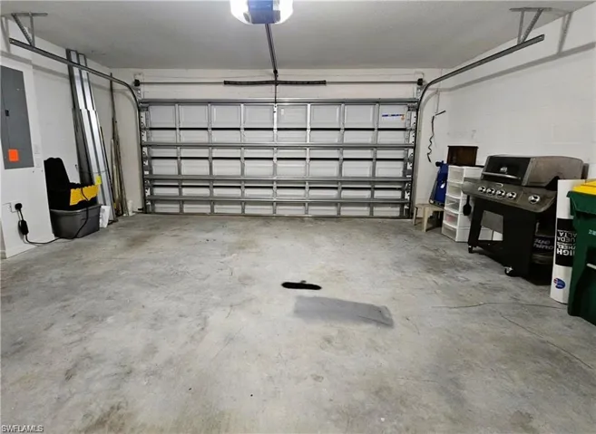Garage featuring electric panel and a garage door opener