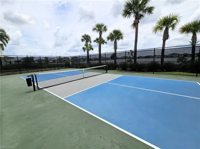 View of tennis court featuring community basketball court and fence