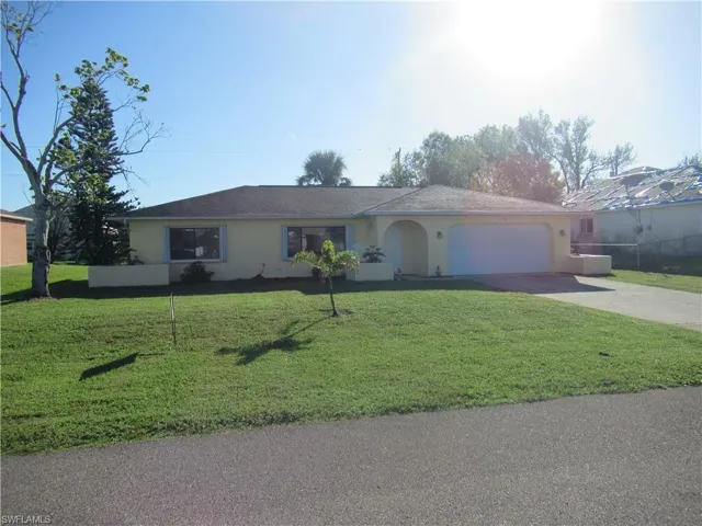 Single story home featuring a front yard and a garage