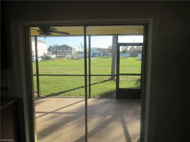 Doorway to outside with tile patterned floors and ceiling fan
