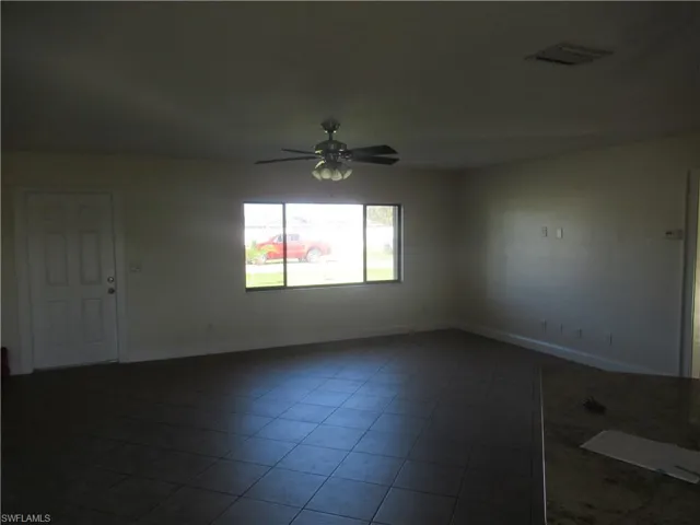 Tiled empty room with ceiling fan