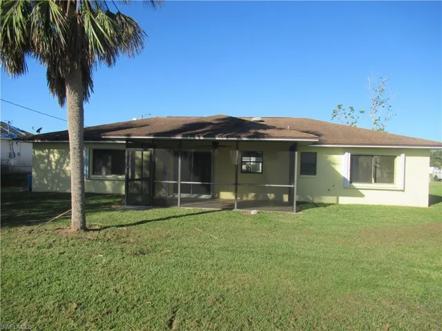 Back of property featuring a yard