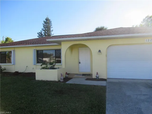 Single story home featuring a front yard and a garage