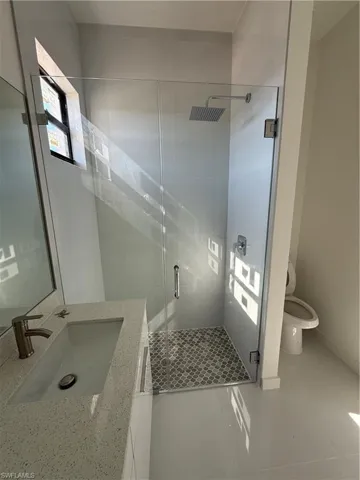 Bathroom with vanity, a stall shower, and light tile patterned floors