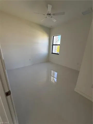 Spare room with ceiling fan and baseboards