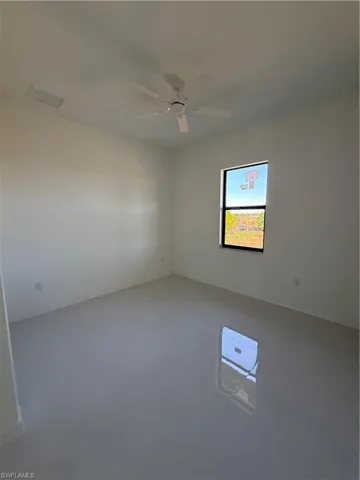 Empty room featuring ceiling fan and concrete flooring