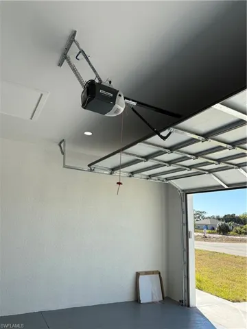 Garage featuring a garage door opener and recessed lighting