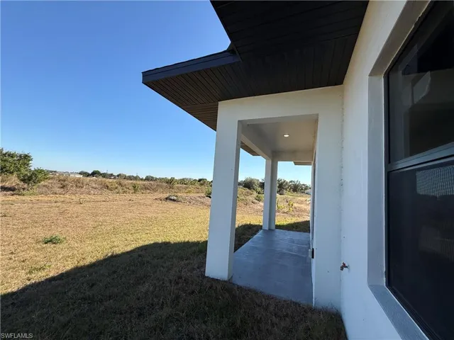 View of green lawn with a patio area
