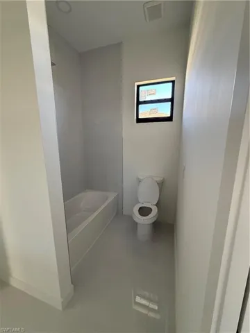 Bathroom with toilet and light tile patterned flooring