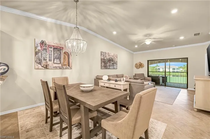 Dining space featuring ornamental molding, recessed lighting, a chandelier, a ceiling fan, and light tile patterned floors