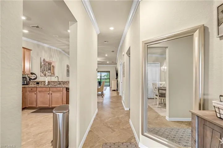 Entry hall featuring ornamental molding, a textured wall, and recessed lighting