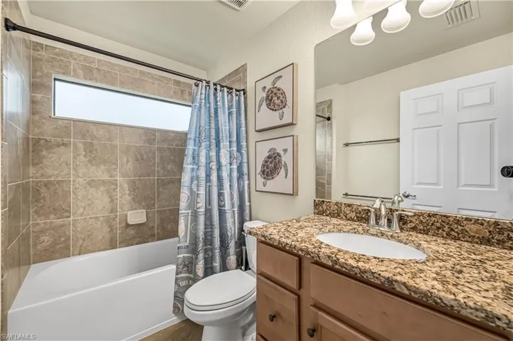 Full bathroom featuring shower / bathtub combination with curtain and vanity