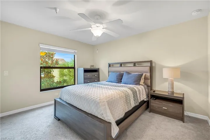 Carpeted bedroom featuring baseboards and ceiling fan