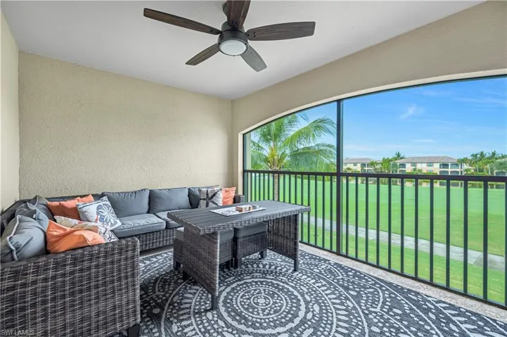 Lanai with TV and golf course view featuring a water view