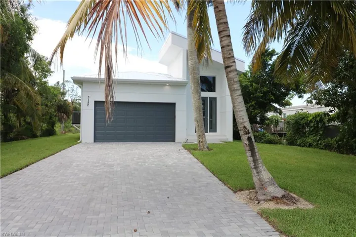 View of front of home featuring a garage and a front lawn