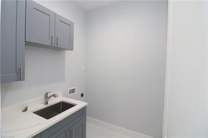Washroom featuring washer hookup, sink, cabinets, and electric dryer hookup