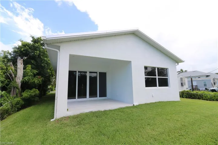 Rear view of house with a patio area and a yard