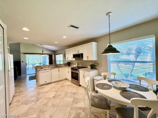 Kitchen with visible vents, range hood, a sink, a peninsula, and stainless steel appliances