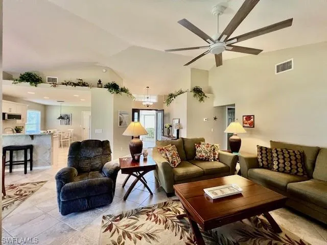 Living area featuring visible vents, a ceiling fan, light tile patterned flooring, and a wealth of natural light