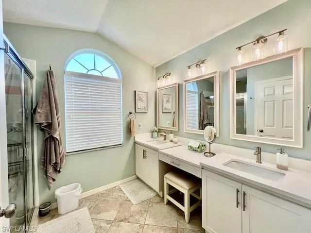 Bathroom with a sink, a stall shower, and vaulted ceiling