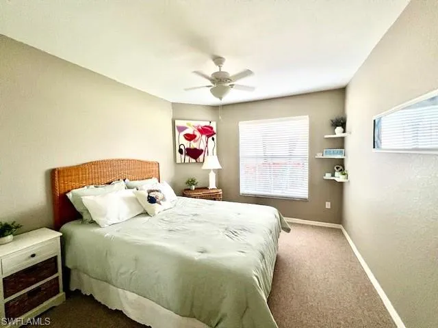 Carpeted bedroom featuring baseboards and ceiling fan