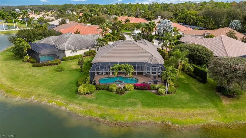 Aerial perspective of suburban area featuring a large body of water and a pool
