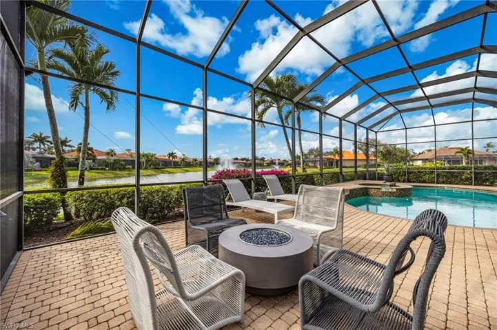 View of patio with a sunroom, a lanai, a residential view, an outdoor fire pit, and a pool with connected hot tub