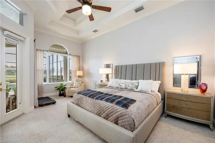 Bedroom with access to exterior, a raised ceiling, carpet, a ceiling fan, and ornamental molding