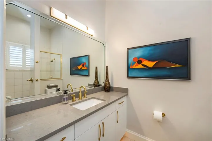 Full bath featuring tiled shower and vanity